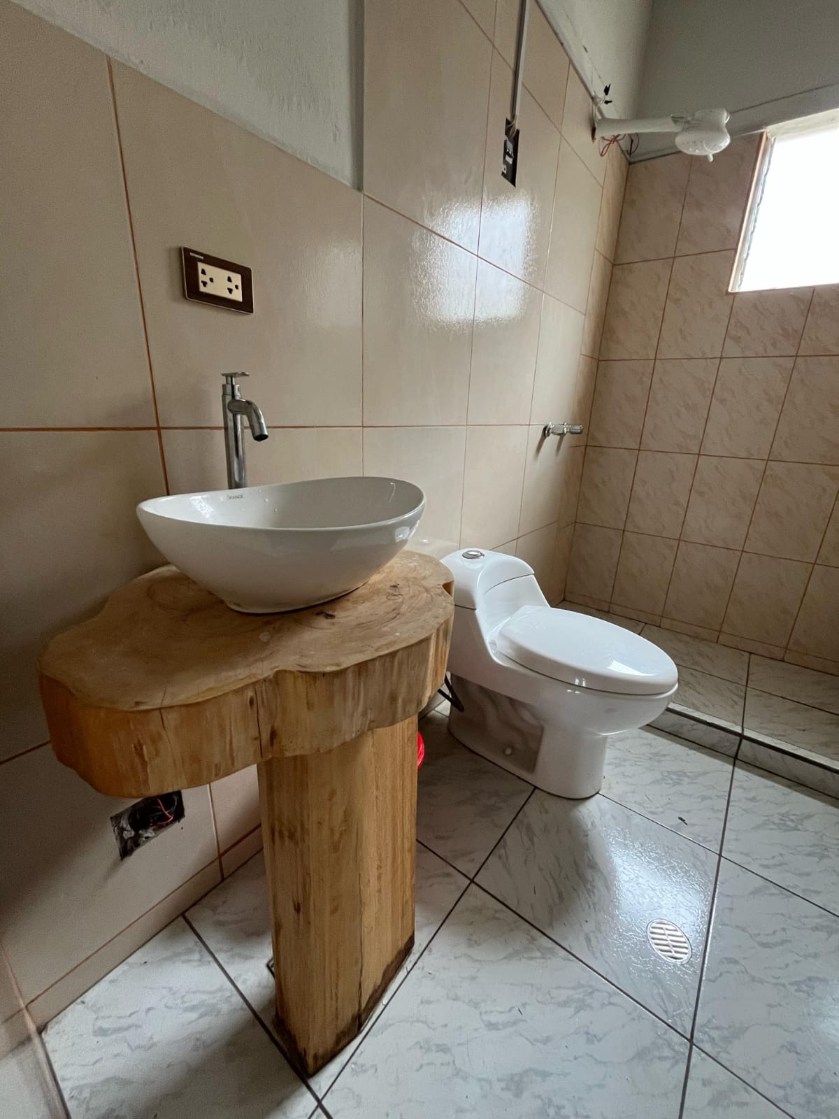Lavabo de cerámica sobre un tronco de madera