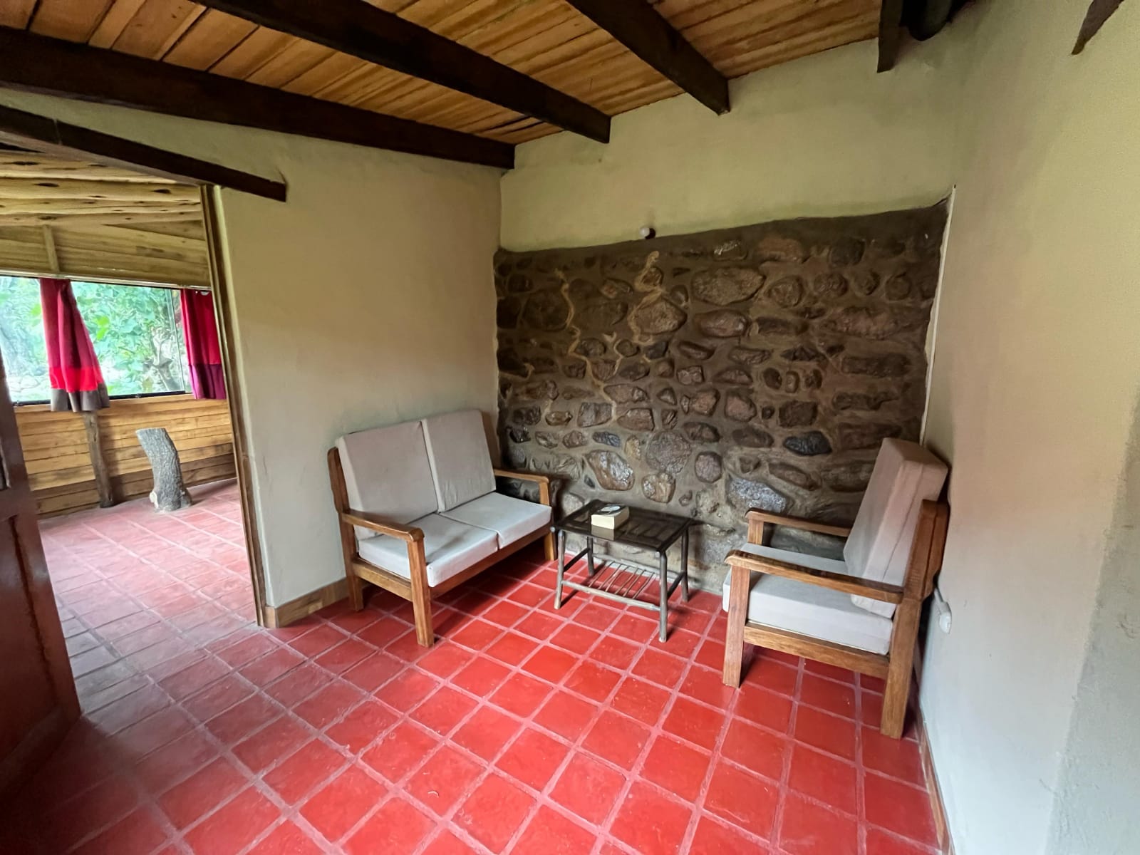 Bungalow Familiar: estar con muro de piedra y vista al jardín